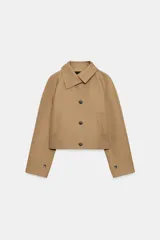 Chaqueta corta ZARA WOMAN COLLECTION de color tostado, con cuello subido y manga larga con trabilla y botón. Cuenta con bolsillos de vivo en el delantero y cierre frontal con botones oscuros.