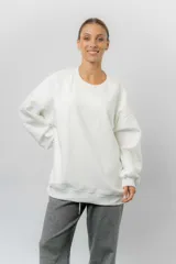 Buzo oversize de cuello redondo, confeccionado en algodón suave con interior frizado. Presenta un diseño de líneas simples, corte relajado y mangas largas con puños ajustados.