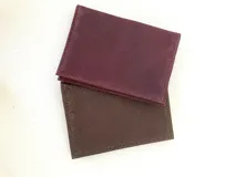 Tarjetero de cuero vacuno color bordó con costuras rojas. Tiene seis ranuras para tarjetas.