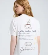 Remera de algodón color blanco con cuello redondo y manga corta. Presenta un estampado temático de la serie Gilmore Girls en la espalda con diseño de taza de café y texto descriptivo.