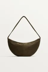Bolso de hombro con diseño de media luna, confeccionado en piel con acabado de serraje. Cuenta con un asa integrada y cierre principal mediante cremallera.