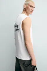 Camiseta sin mangas de corte relajado, con cuello redondo y diseño liso en color blanco.
