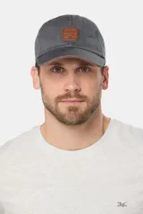 Gorro con visera de lona color gris oscuro, con parche de cuero sintético en el frente y detalle en el borde de la visera.