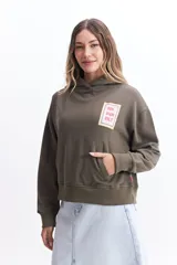 Canguro blanco de felpa con capucha ajustable, bolsillos frontales tipo canguro y estampado en frente y espalda.