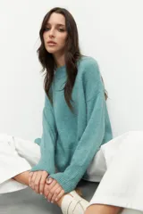 Polera de punto color negro, con cuello alto y mangas largas de corte holgado.