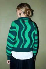 Sweater de tejido de punto con cuello polo y tapeta de botones, presentando un diseño de rayas onduladas anchas en dos tonos de verde.