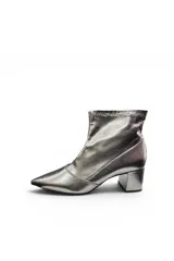 Bota corta de tacón ancho, color plateado metalizado, con punta fina y diseño ajustado al tobillo.