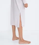 Camisón largo de tejido de punto color gris claro, con cuello alto y mangas largas. Tiene aberturas laterales.