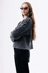 Sweater de punto grueso con textura marcada, de silueta relajada y diseño amplio, con cuello redondo y puños acanalados.