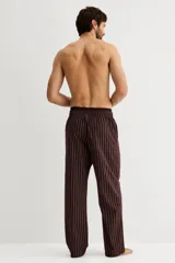 Pantalón de popelina color bordó con finas rayas verticales blancas. Presenta cintura elástica con cordón ajustable y bolsillos laterales. Corte relajado.