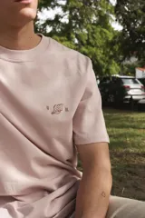 Remera de algodón color verde claro con cuello redondo y un pequeño bordado en el pecho.