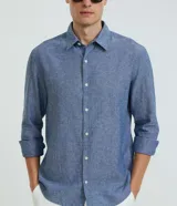 Camisa comfort de manga larga y cuello inglés, confeccionada en mezcla de lino y algodón. Presenta un diseño básico sin estampa con cierre frontal de botones.