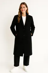 Tapado de paño color negro, de corte recto y largo hasta la rodilla. Presenta cuello con solapas clásicas, cierre frontal con dos botones y bolsillos laterales.