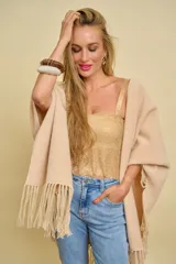 Ruana de lana color bordó con terminación de flecos en los extremos y diseño en picos en la espalda.