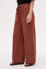 Pantalón de algodón color terracota, de tiro alto y calce holgado, con cintura elástica con cordón ajustable y bolsillos frontales aplicados.