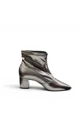 Bota corta de tacón ancho, color plateado metalizado, con punta fina y diseño ajustado al tobillo.