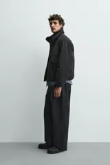 Cazadora acolchada de corte boxy fit, color negro, con cuello subido, cierre frontal de cremallera, bolsillos con solapa en la cadera y bajo con acabado elástico.