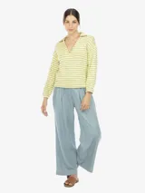 Pantalón celeste amplio de tencel con caída suave y pinzas delanteras. Tiene tiro alto y cintura elástica en la parte trasera.