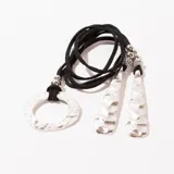 Collar con cordón negro, dije circular plateado y colgantes con forma de lágrima texturizadas.