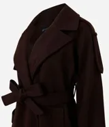 Trench coat largo color marrón chocolate, confeccionado en tejido tipo paño, con solapas amplias, cierre frontal cruzado con cinturón de la misma tela para anudar y detalles de trabillas en los hombros y puños.
