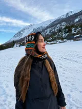Pasamontañas tejido a mano de lana con diseño étnico y geométrico en tonos negro, blanco, naranja y turquesa.