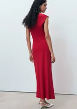 Vestido midi de poliéster color rojo, sin mangas, con cuello redondo y tirantes anchos. Cuenta con diseño entallado, fruncido lateral, forro interior y cierre de cremallera en la parte posterior.