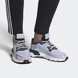 Championes Adidas Nite Jogger, modelo femenino, con diseño multicolor en tonos lila, celeste y negro. Presenta una capellada de malla con perforaciones y superposiciones de cuero, entresuela con tecnología Boost para mayor amortiguación y suela de goma.