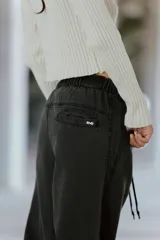 Pantalón de jean gris oscuro, tiro medio, corte tipo babucha, con logo de Renée Club bordado con hilo color a tono en el bolsillo.