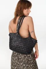 Cartera shopper de cuero negro con diseño trenzado artesanal y asas de hombro.