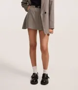 Short pollera de corte sastrero, color gris con estampado de cuadros. Presenta cintura fija, cierre con cremallera, bolsillos y cinturón de poliuretano.