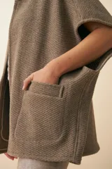 Chaleco marrón de lana con cuello mao, solapas pronunciadas, bolsillos ojal y terminaciones envivadas.