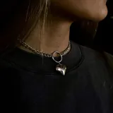 Gargantilla plateada de eslabones gruesos con dije de corazón inflado.