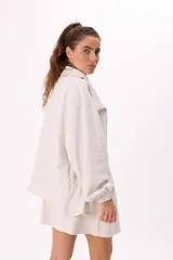 Conjunto deportivo compuesto por un buzo con cierre frontal y una falda corta, confeccionados en algodón liviano. El buzo presenta cuello alto, mangas largas con puños elásticos y un diseño holgado.