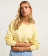 Suéter negro de punto leve, corte boxy, cuello redondo y mangas largas con puños y bajo acanalados.