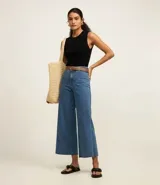 Blusa sin mangas color beige confeccionada en tejido de punto con textura acanalada y cuello redondo.