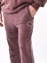 Pantalon de jogging negro con cintura elástica y cordón ajustable. Presenta un pequeño logo circular estampado en la pierna izquierda y bolsillos laterales.