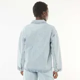 Campera vaquera de denim celeste claro, con cuello clásico, cierre frontal de botones metálicos, bolsillos frontales de parche y mangas largas.
