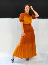 Falda larga color ocre con teñido degradado horizontal en tonos anaranjados. Confeccionada en algodón tipo seda, corte a la cintura, bolsillos laterales y cierre invisible.