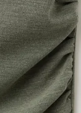 Vestido largo asimétrico de color verde, diseño entallado sin mangas, con detalle metálico en el hombro.