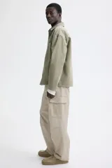 Pantalón cargo de lona de algodón con corte relajado, bolsillos laterales con solapa, bolsillos al bies y pliegues reforzados en las rodillas.