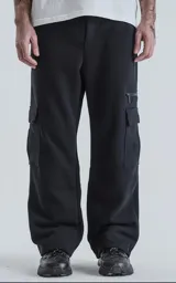 Pantalón tipo jogger de calce baggy con silueta amplia y relajada, confeccionado en frisa pesada de algodón. Cuenta con cintura elástica, bolsillos laterales de mano y bolsillos estilo cargo con solapa y cierre.