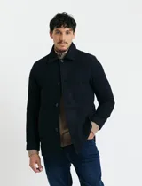 Sobretodo corto de paño en color azul marino, con cuello camisero, cierre frontal mediante botones y manga larga.