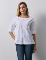 Blusa blanca de algodón, manga corta amplia, con escote redondo y detalle de botones en los tajos laterales del ruedo.