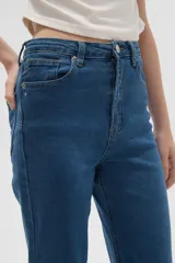 Pantalon de jean gris de corte recto y tiro alto, con cierre frontal y bolsillos laterales.