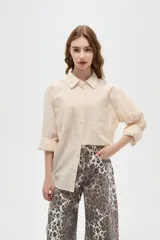 Camisa de algodón con estampado de rayas verticales finas, cuello camisero, cierre frontal con botones y bolsillos frontales tipo parche.