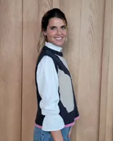 Chaleco tejido de punto con diseño abstracto en bloques de color marrón y turquesa, con cuello redondo y terminaciones acanaladas.