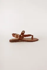 Sandalias negras de cuero con tira de dedo, tira sobre el empeine con hebilla y apliques de tachas plateadas.