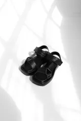 Sandalias bajas color beige con plataforma y tiras anchas de cuero.