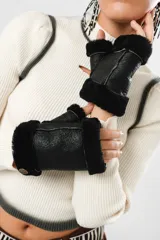 Guantes mitones negros de cuero con borde de lana natural.