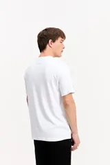 Remera blanca de manga corta con estampa abstracta y tipográfica en el frente.